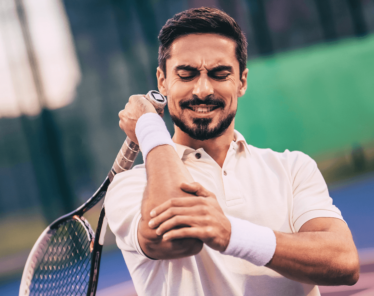Male tennis athlete grimacing with tennis elbow and wishing for Battle Balm all natural topical pain relief cream