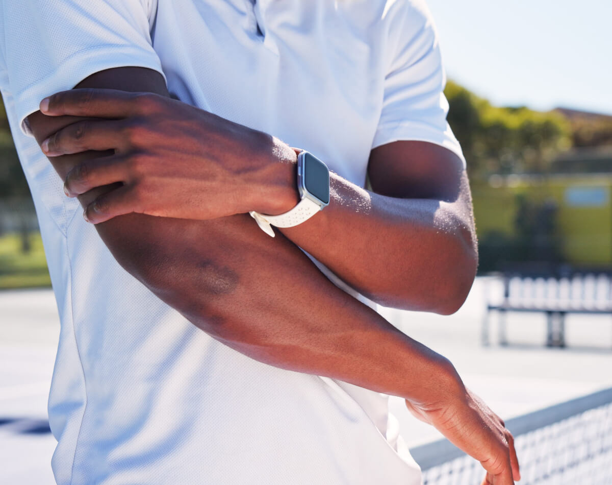 Male pickleball player holding elbow in pain after sports injury