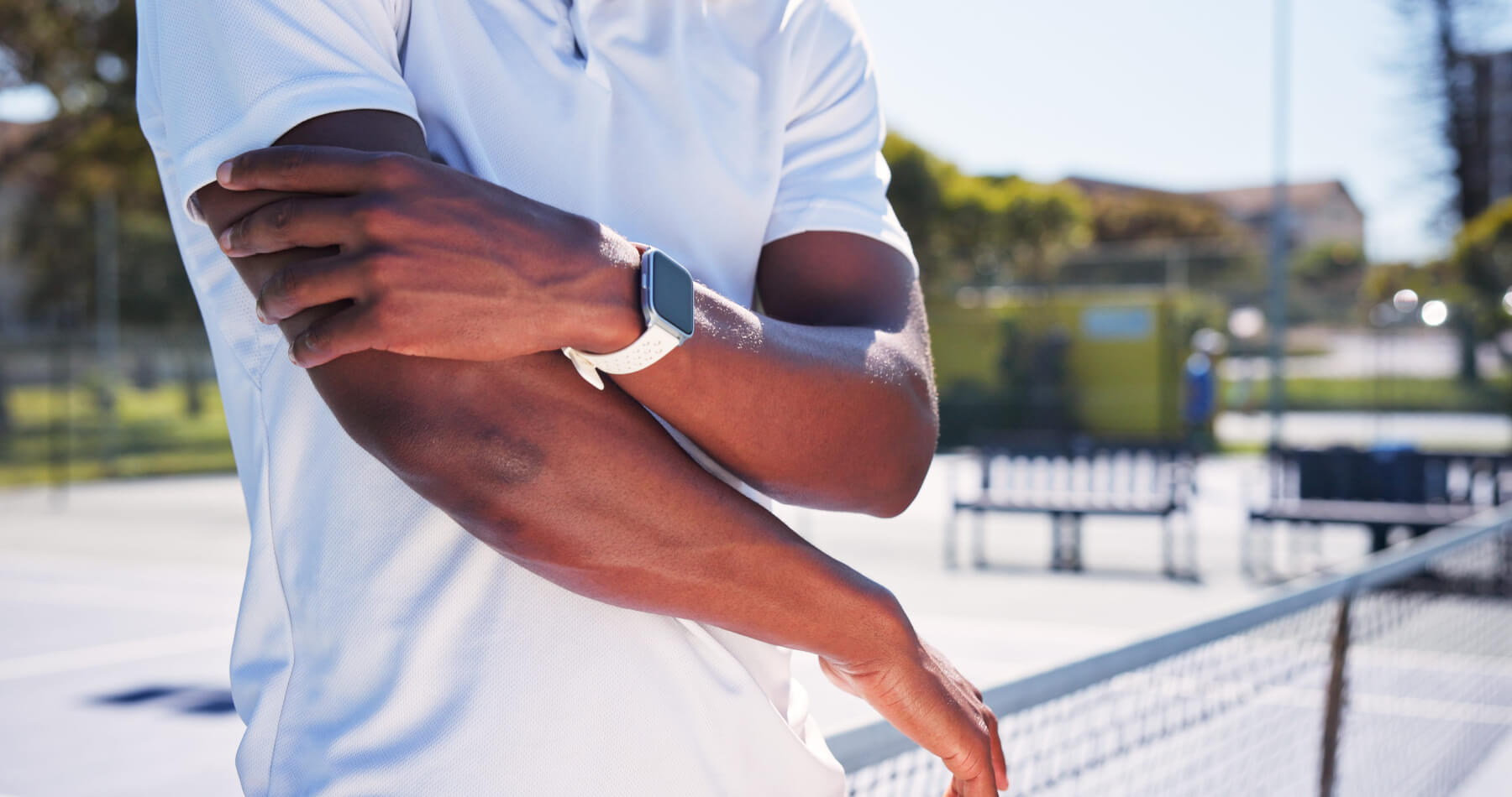 Male pickleball player holding elbow in pain after sports injury